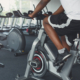 Young unrecognizable man on exercise bike in gym. Male legs in fitness club. Healthy lifestyle concept